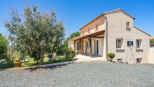 A two-story building with a covered porch, a basketball court, and a gravel driveway. - Villa 'Cap Mer 17' with Private Pool, Private Terrace and Wi-Fi (Saint-Palais-sur-Mer)