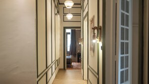 A hallway with a wooden floor, white walls, and a door on the right. - Historic Boutique Apartment in Downtown Cairo (Cairo Governorate)