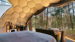 A tent-style bedroom with a bed, a green sofa, a small table, and a microwave. - Mirrored Lost Lake Dome In Cosby - Your Ultimate Hideaway! (Cosby)