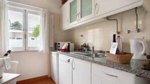 A kitchen with white cabinets, a sink, a toaster, and a coffee maker.