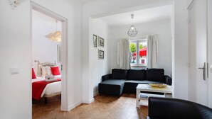 Una habitación con una cama, un sofá, una pequeña mesa y una silla.