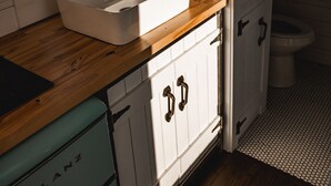 Een keuken met een witte gootsteen, een houten aanrechtblad en een retro Galanz fornuis.