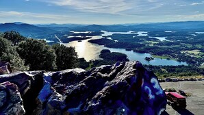 Een panoramisch uitzicht op een rivierdal met bergen op de achtergrond en een heldere lucht.