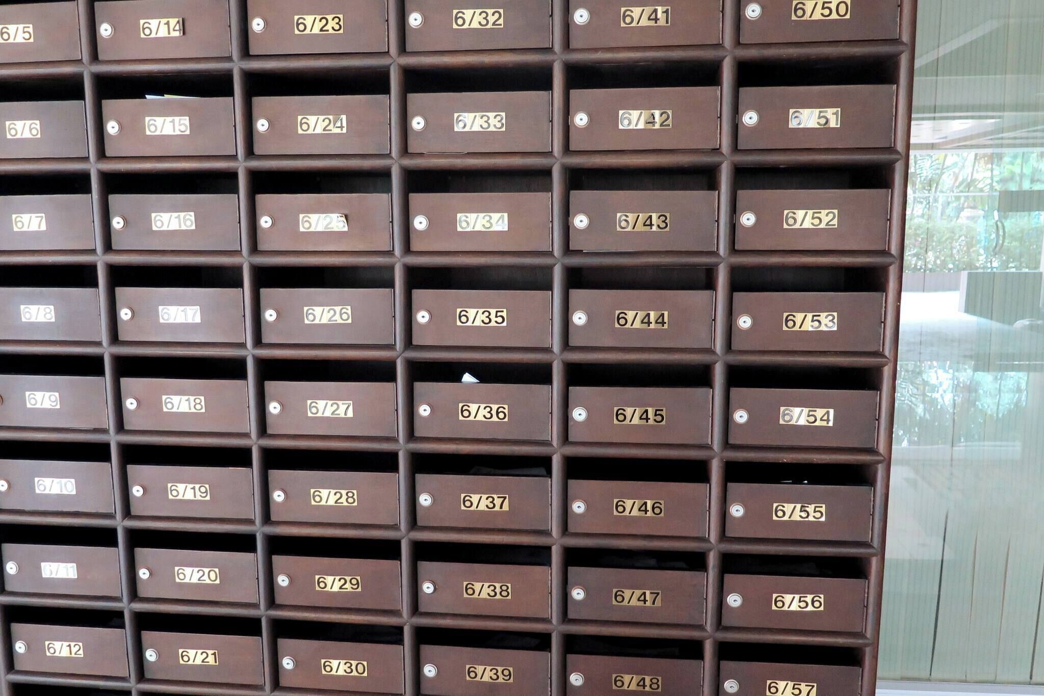 Eine Wand aus Metall-Briefkästen mit Beschriftungen, die Zimmernummern angeben.