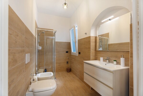 Une salle de bain moderne équipée d’une douche, de toilettes et d’un meuble-lavabo.