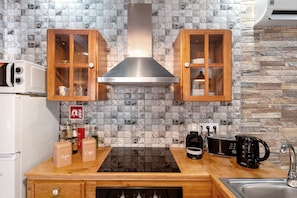 Uma cozinha com armários de madeira, um exaustor de aço inoxidável, micro-ondas, torradeira e cafeteira.