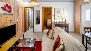 Un salon avec un canapé, un téléviseur et des murs en bois.