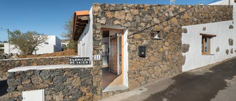 A stone building with a sign reading 'EL RINCÓN DE YÉICO'.