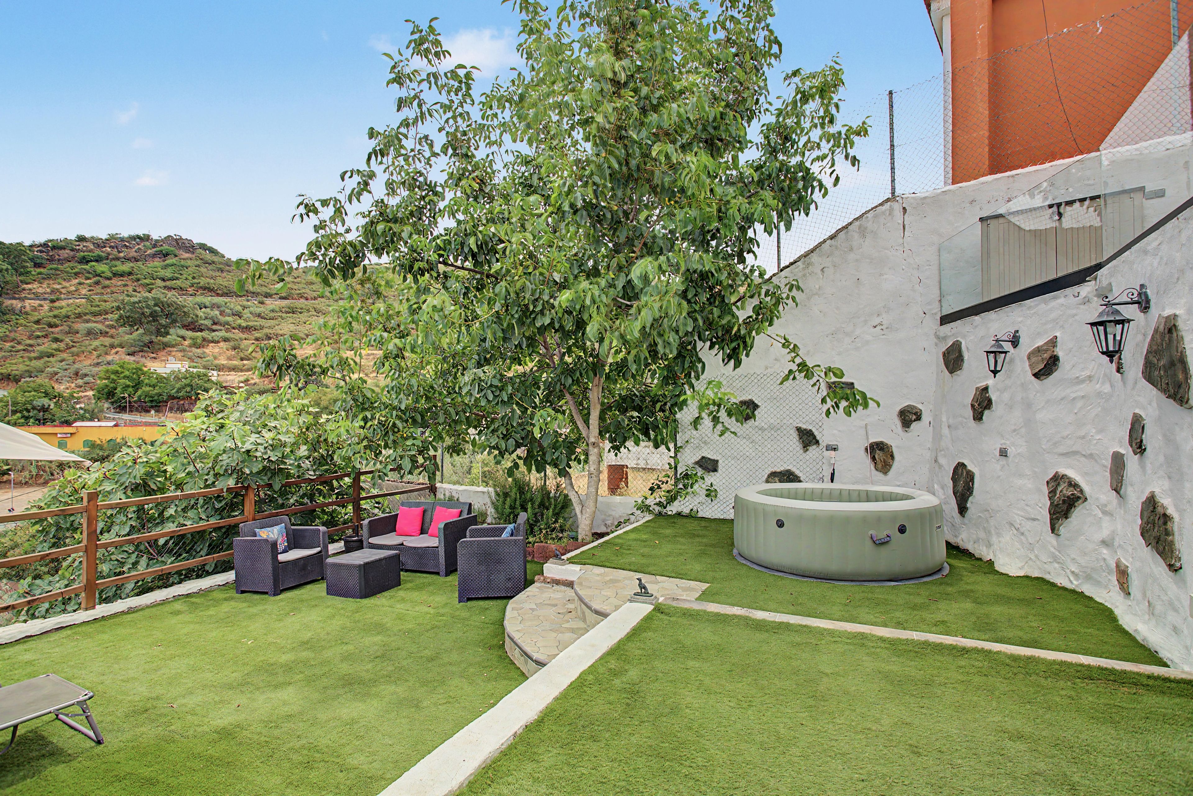Un espace patio aménagé avec du mobilier d’extérieur, un jacuzzi et une vue sur le paysage environnant.