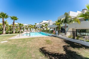 Una piscina rodeada de palmeras y edificios modernos.