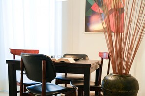 A dining area with a table, chairs, and a vase with tall plants. - Milano Centro, Pellegrini House (Milano)