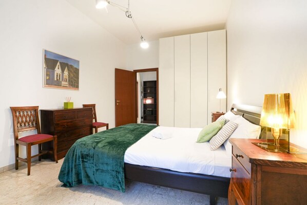 A bedroom with a bed, dresser, chair, and a painting on the wall. - Milano Centro, Pellegrini House (Milano)