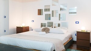 A modern bedroom with a large bed, multiple mirrors, and bedside tables with lamps. - Milano, Industrial Loft (Milano)