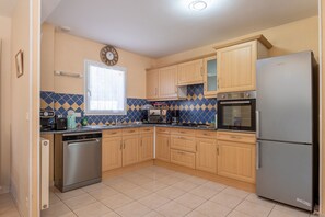 A kitchen with wooden cabinets, a stainless steel dishwasher, a built-in oven, and a Samsung refrigerator.