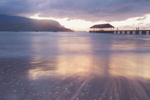A calm waterfront with a pier and a covered structure. - (HH9B) Classic Hawaiian Hale Honu 2br 2ba (Princeville)