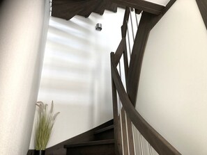 A staircase with wooden railings and a white wall. - "Meeresjuwel" Coralie - "Coralie - Coral" at Meeresjuwel!   (Dahme)