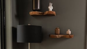 En moderne stue med en sofa, gulvlampe og dekorative reoler.