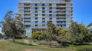 Un hôtel à plusieurs étages doté d’une architecture moderne, avec des balcons à chaque étage et un aménagement paysager soigné.