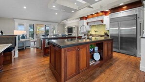 Un'ampia cucina con una grande isola, mobili in legno ed elettrodomestici in acciaio inossidabile.