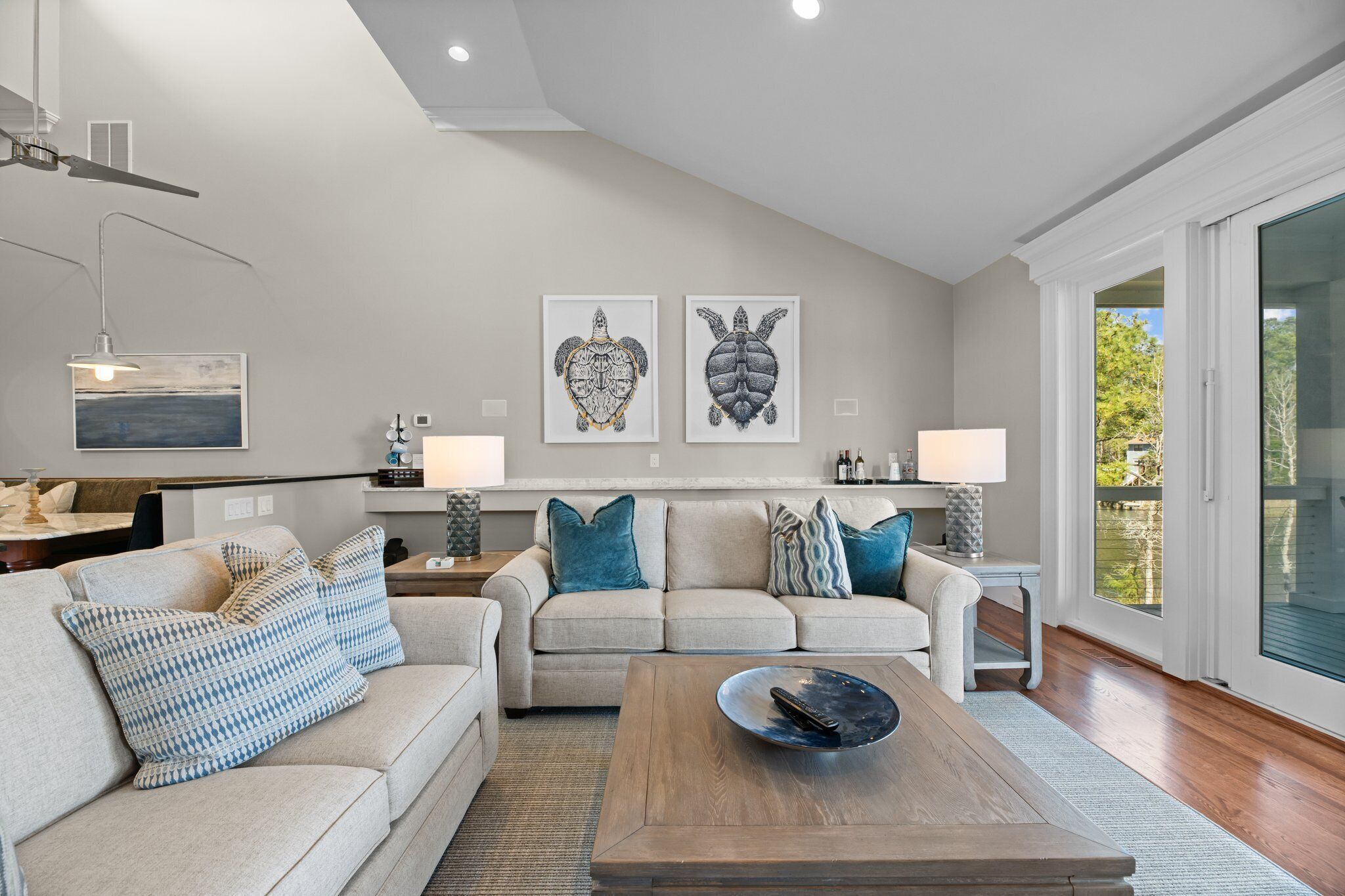A modern living room with two sofas, a coffee table, and artwork on the wall.