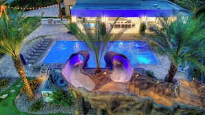 A resort with a pool, lounge chairs, and a waterfall feature. - Palm Villa- Luxury 8 Bed, Pickleball, Volleyball, Golf (Bermuda Dunes)