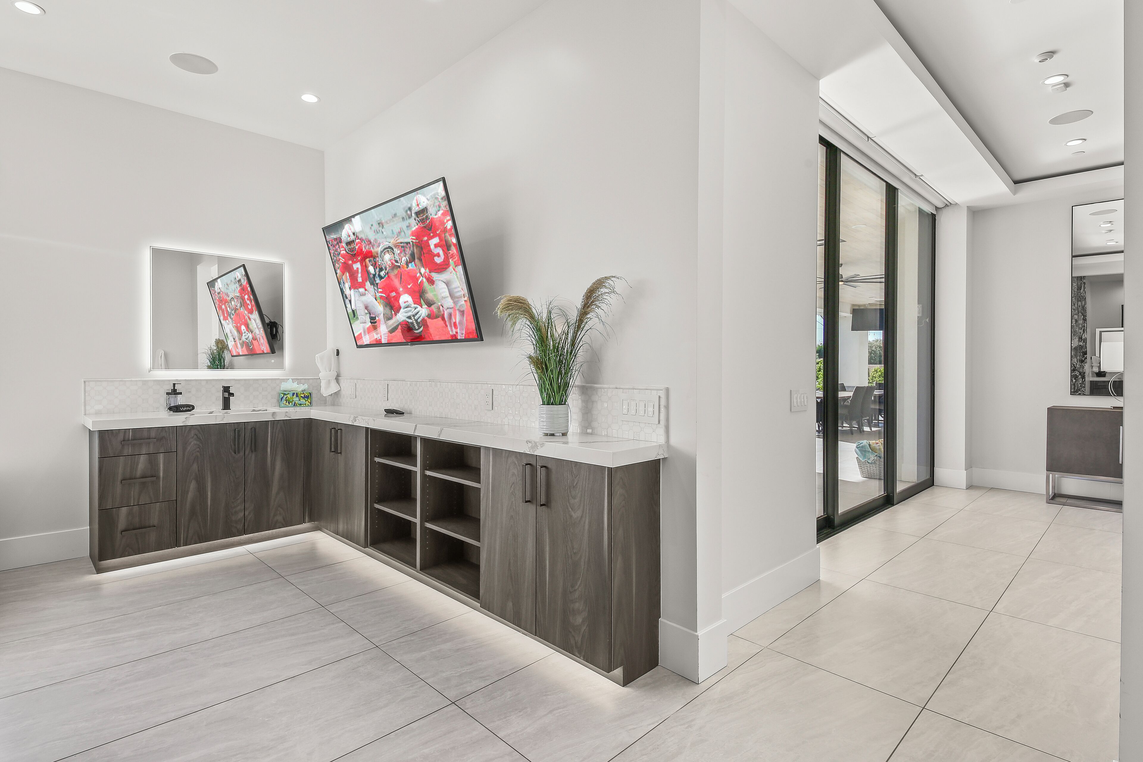 A modern bathroom with a large mirror, a sink, and a shower area.