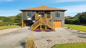A two-story house with a front porch, a staircase, and a garage. - Salty Bunker | 5200 ft to the beach | Private Pool (Kitty Hawk)
