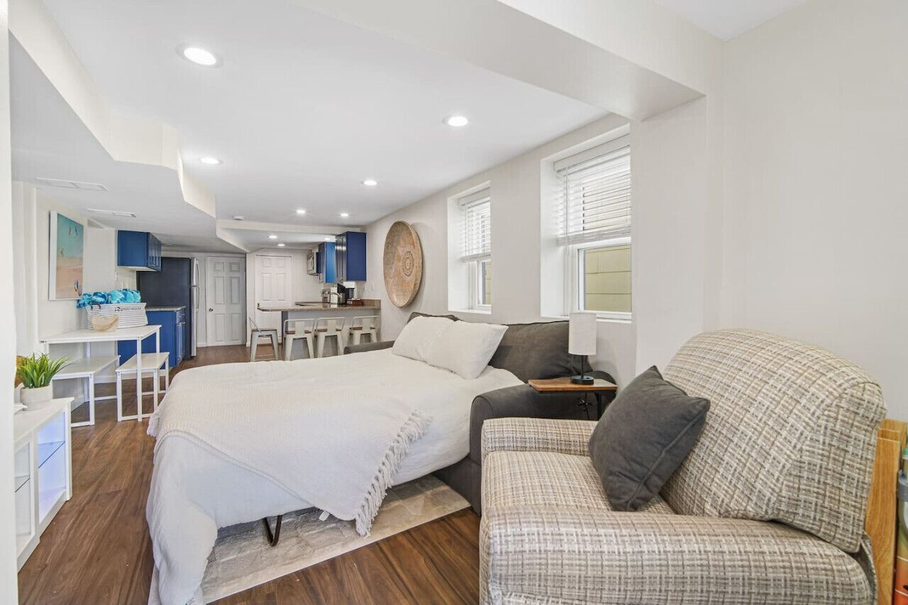Une chambre moderne avec un grand lit, un canapé et un coin bureau avec une chaise.