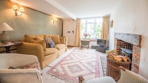 A cozy living room with a sofa, armchairs, a fireplace, and a television. - Angel Cottage, Wenhaston. Nr Southwold and Minsmere (Suffolk)