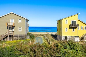 Deux maisons situées en bord de mer, offrant une vue dégagée sur l’océan.