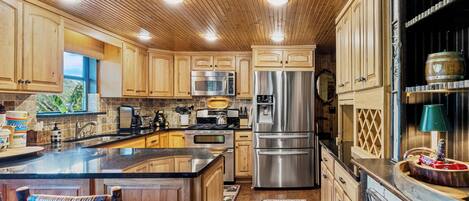 A modern kitchen with wooden cabinets, stainless steel appliances, and a central island.