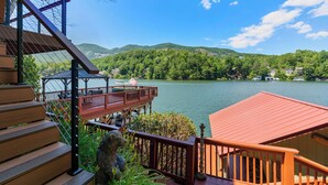 A wooden deck with a view of a lake and mountains.