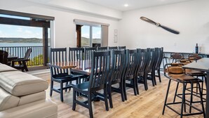 Un comedor moderno con una mesa grande y sillas, un balcón con vistas al paisaje y un ventilador de techo.