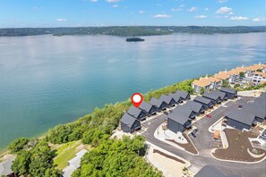 A lakeside property with multiple buildings, a parking lot, and a red location marker.