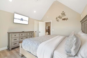 A bedroom with a bed, dresser, and a wall-mounted sign.