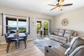 A spacious living area with a dining table, chairs, a sofa, and a ceiling fan. - Table Rock Views with Private Hot Tub, Indoor/Outdoor Pools, Near Silver Dollar City & Free Tickets (Kimberling City)