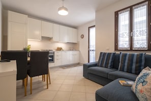 A compact living space with a kitchenette, a dining area, and a sofa.