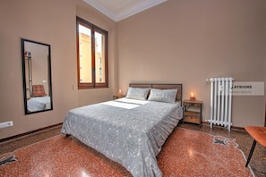A bedroom with a bed, a mirror, a window, a radiator, and a carpet with a floral pattern. - Appartamento Dalì, perfect for regenerating in Rapallo (Rapallo)