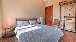 A bedroom with a bed, nightstand, and a wardrobe.