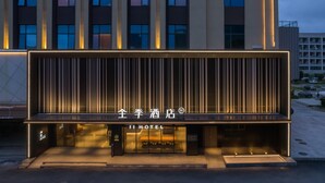 A modern hotel facade with illuminated signage and vertical lines. - Ji Hotel Zhuhai Gaolangang Shopping Center (Zhuhai)