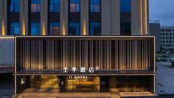 A modern hotel facade with illuminated signage and vertical lines.