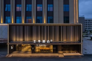 A modern hotel facade with illuminated signage and vertical lines. - Ji Hotel Zhuhai Gaolangang Shopping Center (Zhuhai)