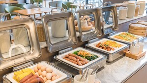 A buffet with various food items in metal containers, including sausages, eggs, corn, and salads. - Ji Hotel Zhuhai Gaolangang Shopping Center (Zhuhai)