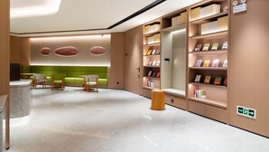 A modern library with bookshelves, seating areas, and a marble floor. - Ji Hotel Zhuhai Gaolangang Shopping Center (Zhuhai)