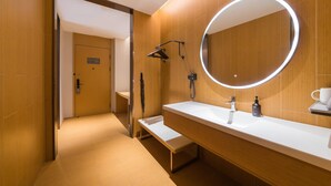 A modern bathroom with a wooden floor, a white sink, a large mirror with a circular light, and a towel rack. - Ji Hotel Zhuhai Gaolangang Shopping Center (Zhuhai)