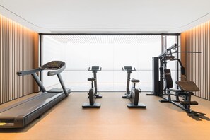 A gym with a treadmill, elliptical, stationary bike, and weight machine. - Ji Hotel Zhuhai Gaolangang Shopping Center (Zhuhai)