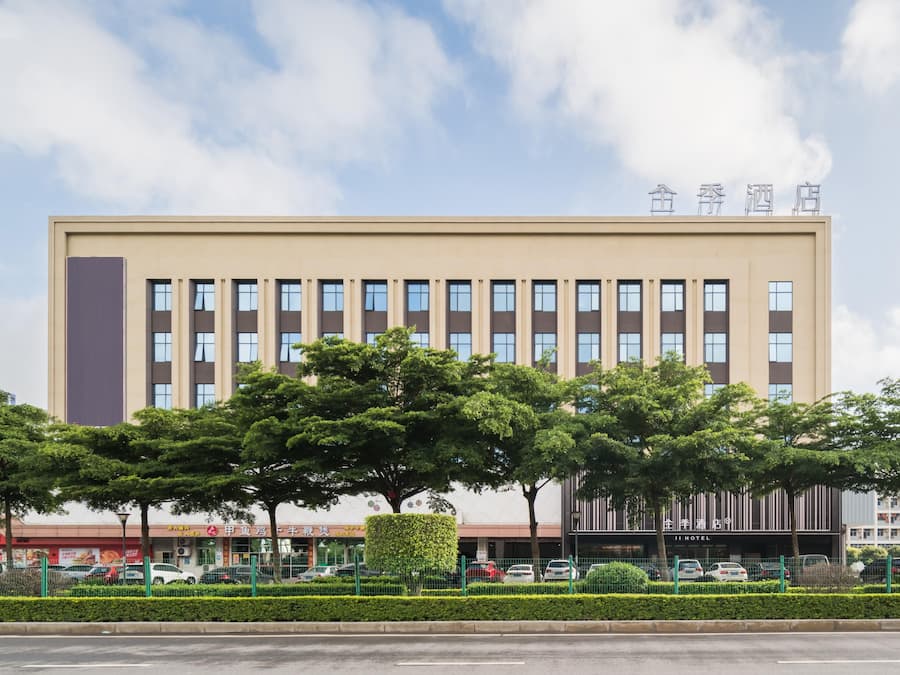 A modern building with a flat facade, multiple windows, and a sign indicating it is a hotel.