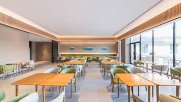 A modern dining area with tables and chairs arranged for seating.