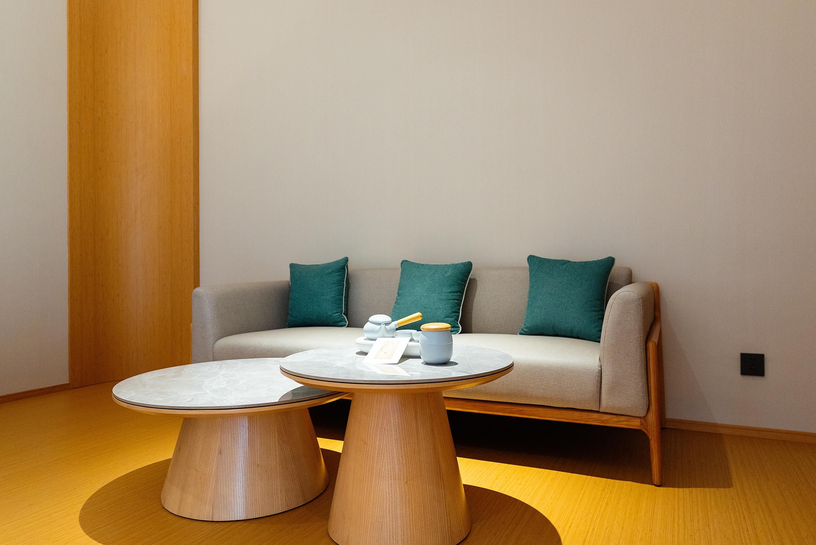 A modern living room with a sofa and two wooden coffee tables.