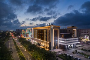 A modern hotel with a prominent sign, a well-lit facade, and a parking area. - Ji Hotel Zhuhai Gaolangang Shopping Center (Zhuhai)